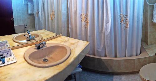 a bathroom with two sinks and a shower curtain at El Ancla in Laredo