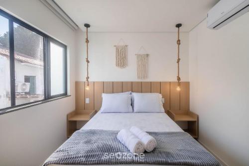 a bedroom with a bed with two towels on it at Estadia completa com piscina e a 350m da Praia PRY in Porto Seguro