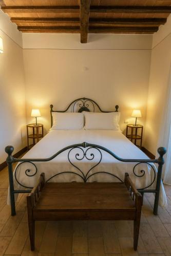 a bedroom with a large bed with a bench at L'orto Delle Terme in Bagno Vignoni