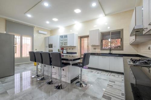 a kitchen with a table and some chairs in it at Dar hamama - Villa familiale - Marrakech in El Aggada