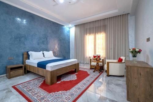a bedroom with a bed and a living room at Dar hamama - Villa familiale - Marrakech in El Aggada