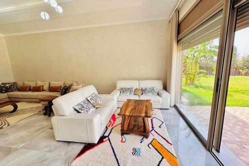 a living room with a couch and a table at Dar hamama - Villa familiale - Marrakech in El Aggada