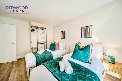 two beds in a room with green and white at Brand New Town Center, Free Fast WiFi, Balcony By Redwood Stays in Aldershot