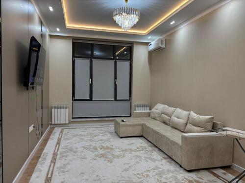a living room with a couch and a large window at Assu in Taraz