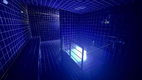 an empty room with a blue light in a room at Apartamentos Recanto do Bosque in Caldas Novas