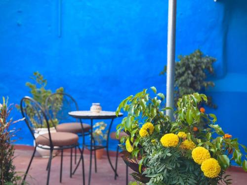 a patio with a table and chairs and yellow flowers at Dar SAAD in Rabat