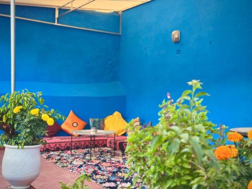 a blue wall with a couch and a table at Dar SAAD in Rabat