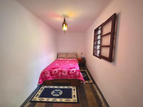 a bedroom with a pink bed and a window at Dar SAAD in Rabat