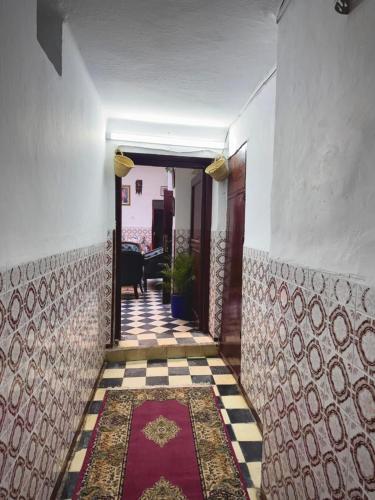 a hallway with a tile floor and a door with a table at Dar SAAD in Rabat