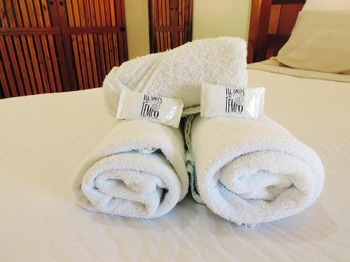 ein Stapel Handtücher auf einem Bett in der Unterkunft Pousada Viajantes do Tempo in Cunha