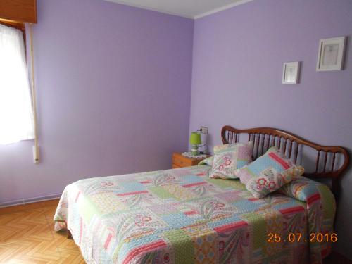 a bedroom with a bed with purple walls at Hotel Alto de las Estazadas in Canales