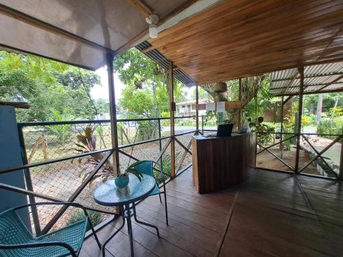 a room with a table and chairs on a balcony at Cahuita Backpackers in Cahuita