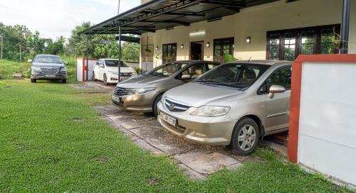 tre auto parcheggiate fuori da un edificio di CLUB 4 Homestay a Nedumbassery