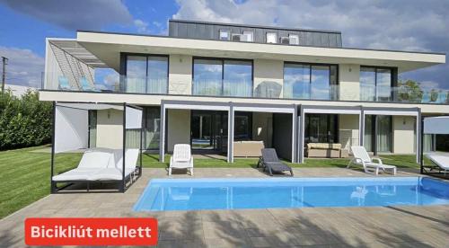 a house with a swimming pool in front of it at Luxury Apartments in Balatonalmádi, Almádi Lux Apartman III - Pure Gold in Balatonalmádi