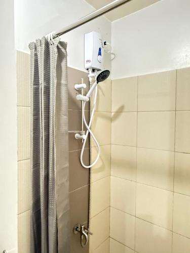 a shower with a shower head in a bathroom at MPlace Tower D Condo Unit in Manila