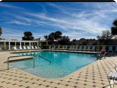 a large swimming pool with blue water at Spacious 2BR in The Villages With Golf Cart and King Bed in Sumterville