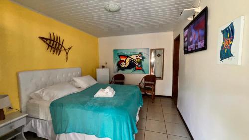 a bedroom with a bed and a tv in it at Pousada Entre as Águas in Imbassai