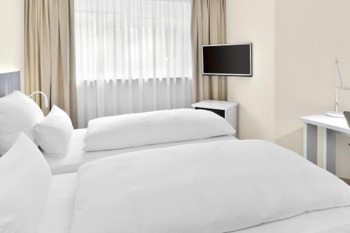 Uma cama ou camas num quarto em NH Fürth Nürnberg