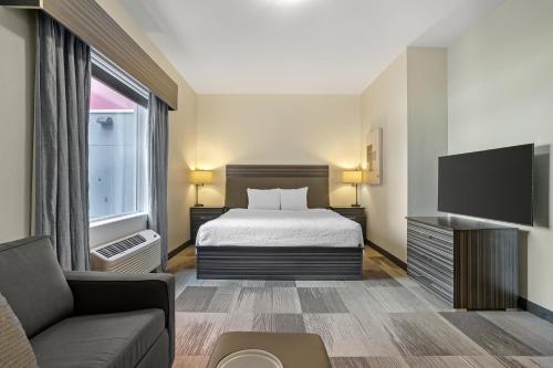 a hotel room with a bed and a tv at Best Western Plus Airport Inn & Suites in Saskatoon