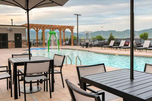 a pool with tables and chairs and a fountain at Staybridge Suites Pigeon Forge - Smoky Mtns by IHG in Pigeon Forge
