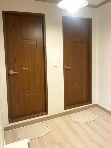 two brown doors in a room with wooden floors at Danaharu Guesthouse in Jeonju