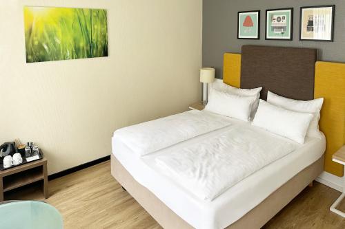 a bedroom with a white bed in a room at Garner Hotel Cologne East by IHG in Cologne