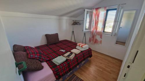 a bedroom with a bed with a blanket on it at Holiday house with a parking space Jadrija, Sibenik - 24931 in Jadrija