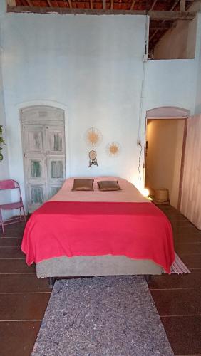 a bedroom with a large bed with a red blanket at Pelourinho House Experience in Salvador