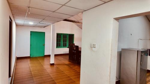 an empty room with green doors and a wooden floor at DNA secret palace in Tangalle