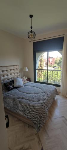 a bedroom with a large bed with a large window at Atlas Golf Resort - Marrakech palmeraie a 6 k m du centre in Marrakesh
