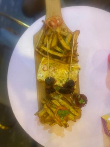 a plate of food with french fries and a fork at Ontario Suites in Lagos