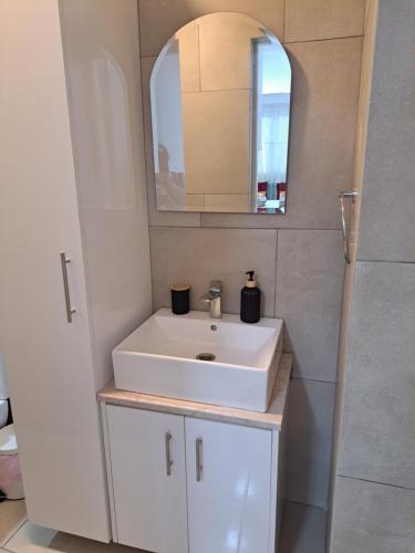 a bathroom with a white sink and a mirror at The Heart of Moutoullas in Moutoullas