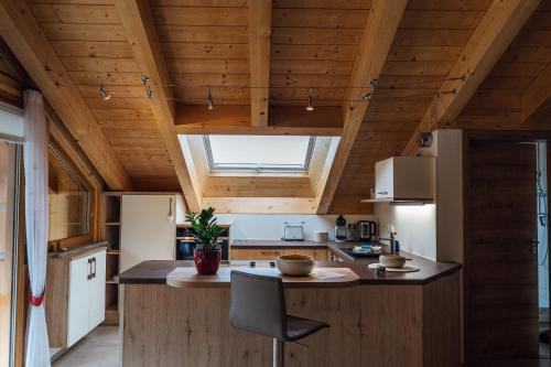 eine Küche mit Holzdecke und einem großen Fenster in der Unterkunft Ferienwohnungen Zur Wally, Apartment Sunnig in Garmisch-Partenkirchen