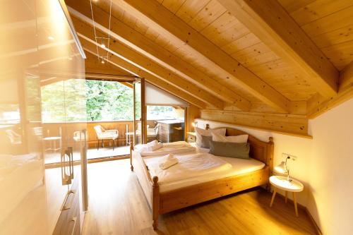 ein Schlafzimmer mit einem Bett in einem Holzhaus in der Unterkunft Ferienwohnungen Zur Wally, Apartment Sunnig in Garmisch-Partenkirchen