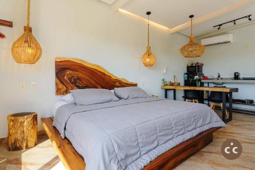 a bedroom with a large bed and a kitchen at Magnifico Loft para 2 con Vista al Mar de Zicatela in Brisas de Zicatela