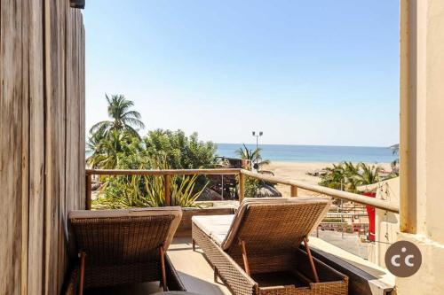 a balcony with two chairs and a view of the beach at Magnifico Loft para 2 con Vista al Mar de Zicatela in Brisas de Zicatela