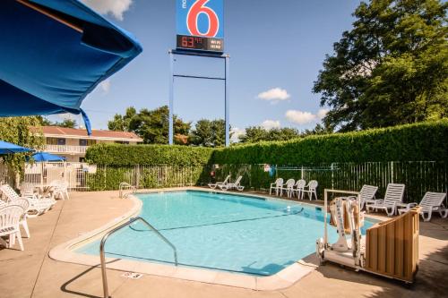 a swimming pool with chairs and a clock on top at Motel 6-Leominster, MA in Leominster
