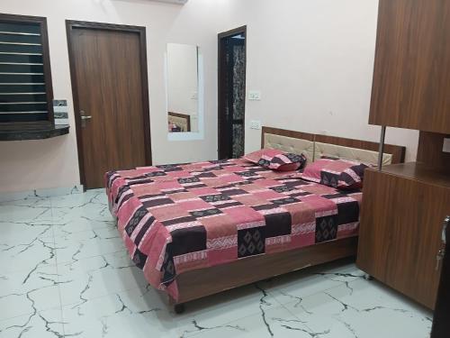 - une chambre avec un lit doté d'une couette rouge et noire dans l'établissement The Imperial Stay, à Chaheru