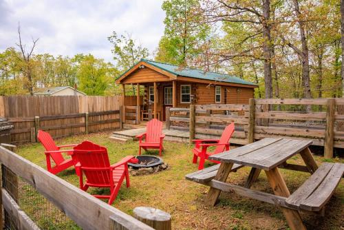 a picnic table and chairs in front of a cabin at Timber Ridge Retreat in Morton Grove