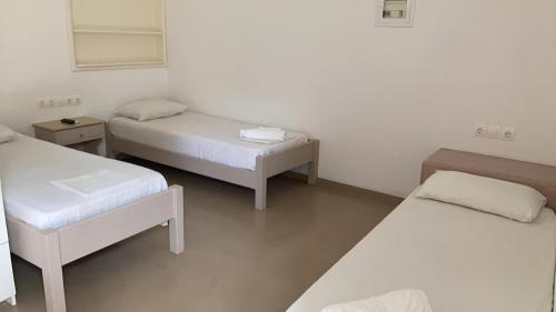 Habitación con 2 camas y 2 mesas en Studio A for 3 guests with kitchen, en Ios Chora