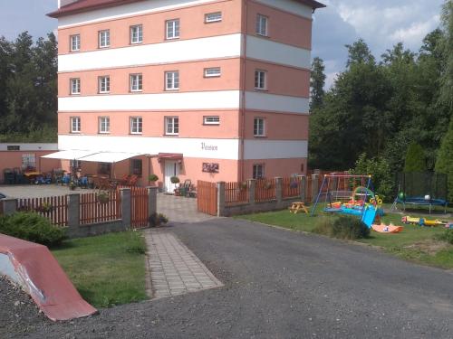 a large building with a playground in front of it at Penzion Hajský mlýn in Nebanice