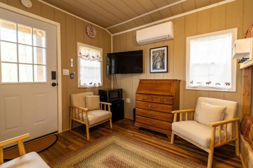 a living room with two chairs and a television at Timber Ridge Retreat in Morton Grove