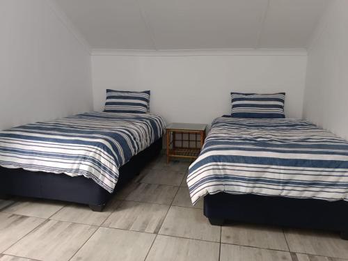 two beds sitting next to each other in a room at Richards Bay Stay in Richards Bay