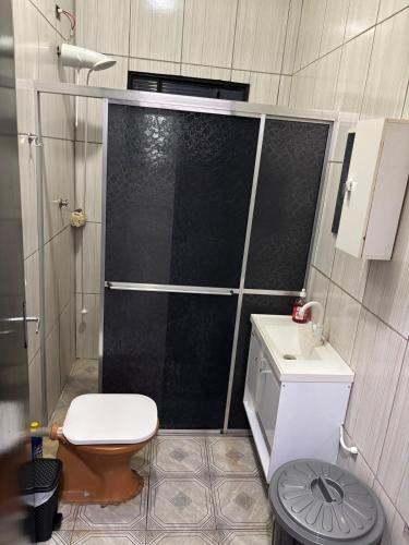 ein Badezimmer mit Dusche, Toilette und Waschbecken in der Unterkunft Casa da Dona Vera in Olímpia