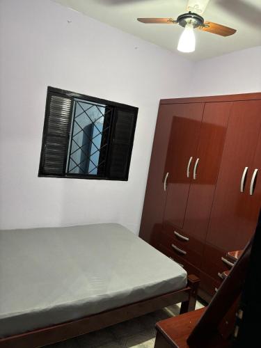 ein Schlafzimmer mit einem Bett, einem Fenster und Schränken in der Unterkunft Casa da Dona Vera in Olímpia