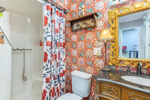 a bathroom with a toilet and a sink and a mirror at Fish, Swim and Grill Lakefront Carolina Home! in Lake Waccamaw