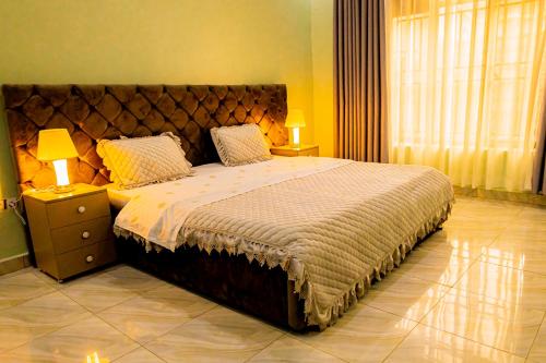 a bedroom with a large bed with two lamps at Modern Furnished House in Kabeza in Kigali