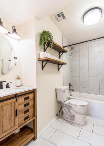 a bathroom with a toilet and a sink and a tub at Full Triplex in Central Tucson EV charging in Tucson