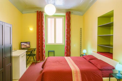 una camera da letto con un letto, una scrivania e una finestra di Sole Rosso Acquario Rooms a Genova