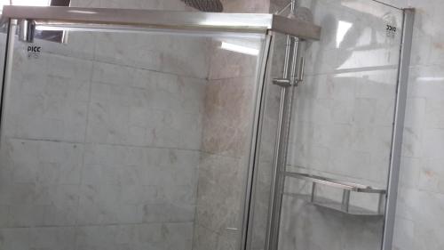 a shower with a glass door in a bathroom at Yofel Hotel in Addis Ababa